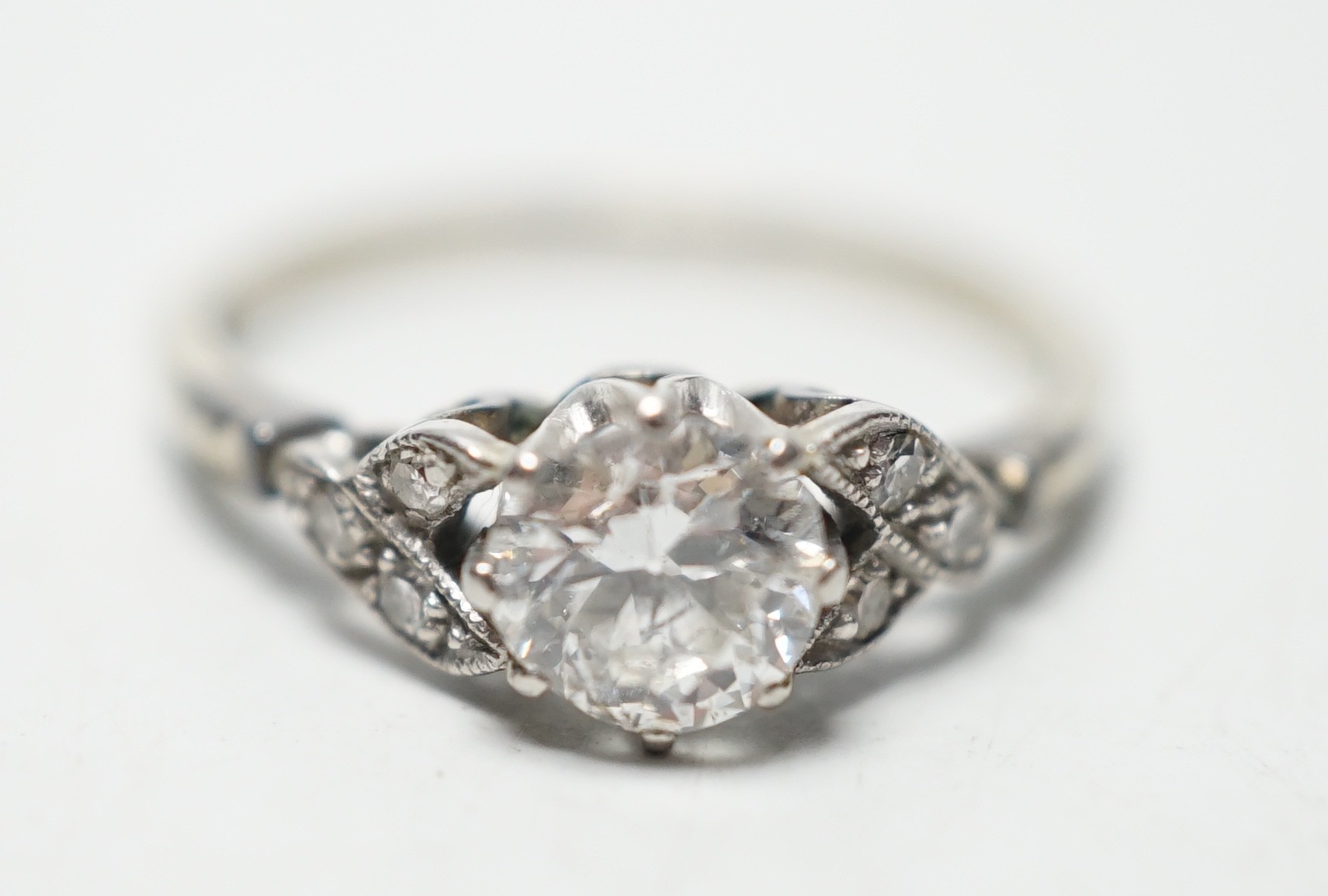 An 18ct white metal and single stone diamond ring, with diamond chip set shoulders, the stone weighing approximately 0.60ct, size M, gross weight 1.8 grams.